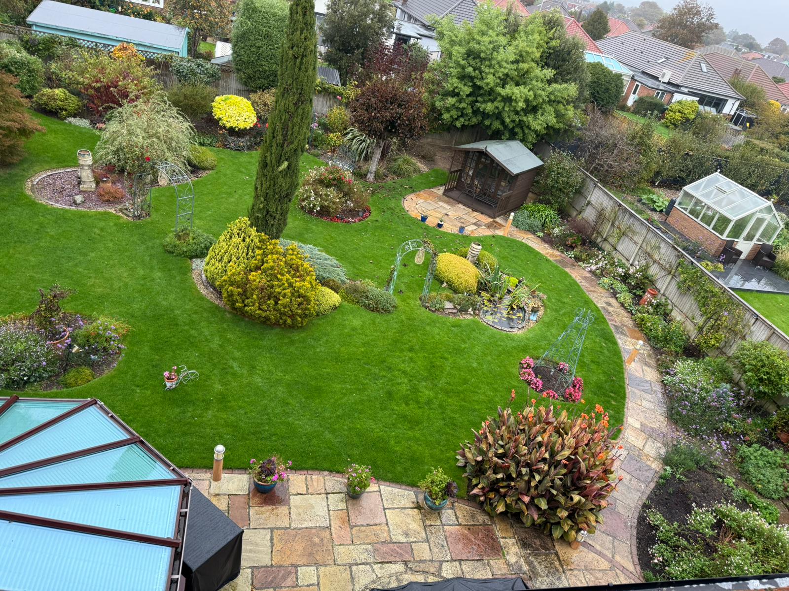 The wide, green garden at dusk with the soft glow of the house.